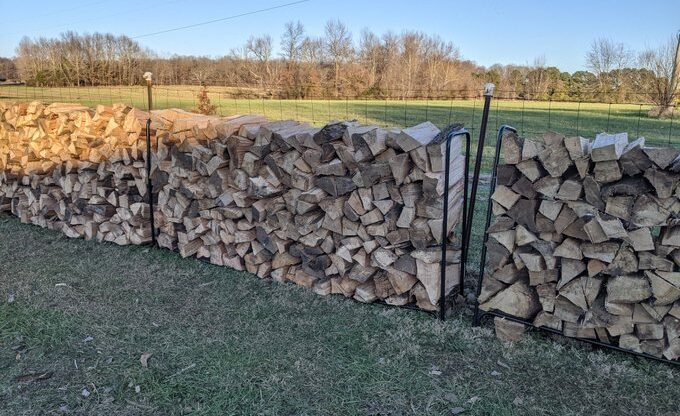 Cord of oak firewood in cheap metal racks